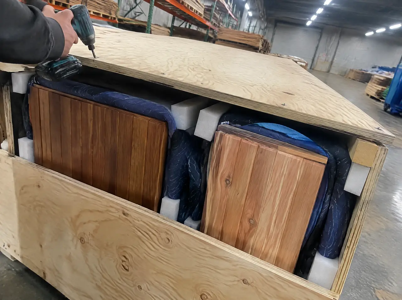 Crate of teak and cedar panels wrapped in blankets